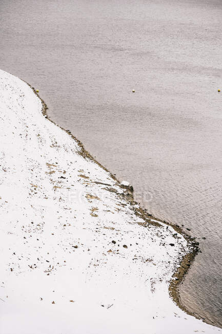 Paisaje de río ondulado que fluye a través de las costas nevadas - foto de stock