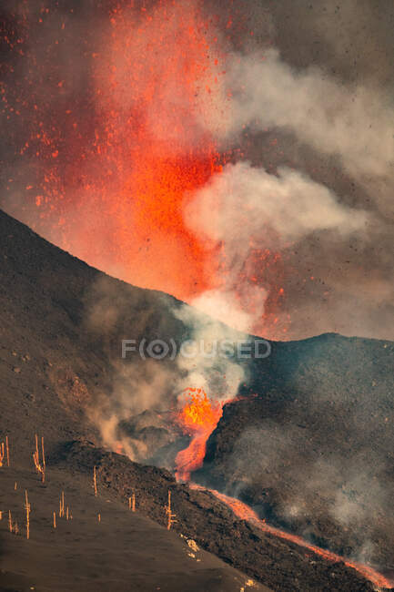 Lava calda e magma fuoriescono dal cratere con pennacchi di fumo. Cumbre Vieja eruzione vulcanica a La Palma Isole Canarie, Spagna, 2021 — Foto stock