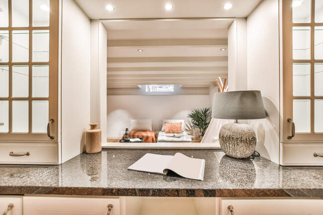 Através da janela do interior contemporâneo de cozinha espaçosa com mesa de jantar e aparelhos variados em casa de campo — Fotografia de Stock