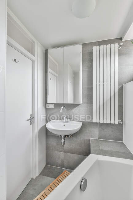 Інтер'єр стильної сучасної ванної кімнати з дзеркалом, що висить над раковиною — стокове фото