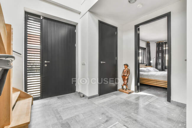 Інтер'єр коридору з сірими стінами і відкритими дверима в спальню в сучасному великому будинку — стокове фото