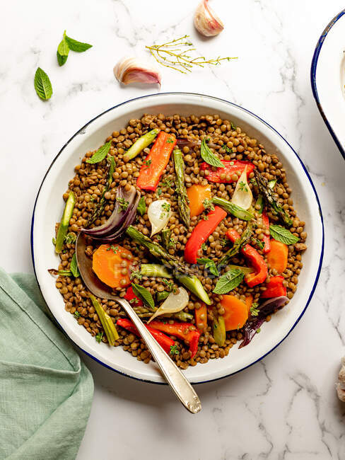 Von oben appetitanregender Linsensalat mit verschiedenen Gemüsesorten in Schüssel serviert auf Marmortisch für ein gesundes Mittagessen — Stockfoto
