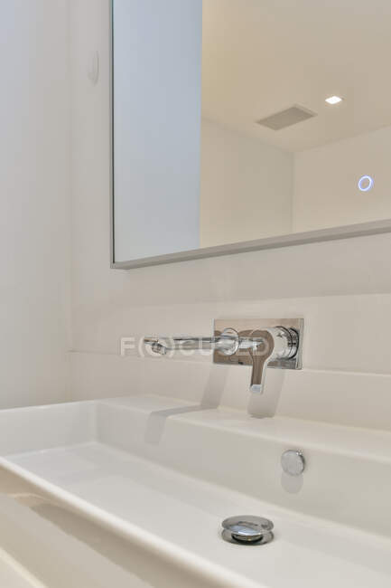 Lavatório de cerâmica branca moderna no banheiro com torneira projetada em estilo mínimo no apartamento — Fotografia de Stock
