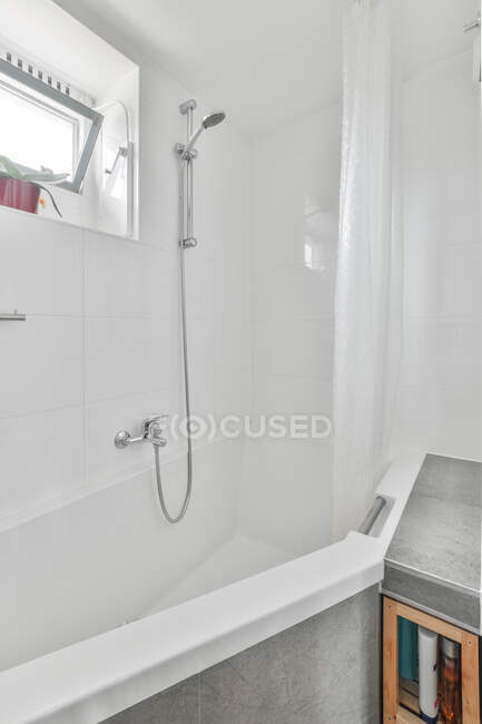 Interior do elegante banheiro contemporâneo com chuveiro sob janela — Fotografia de Stock