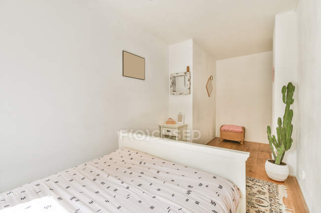 Innenraum des gemütlichen Schlafzimmers mit Topfpflanze und Bett in zeitgenössischem Raum — Stockfoto