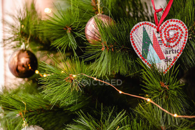 Branches of fir tree decorated with fairy lights and baubles for Christmas celebration — Stock Photo