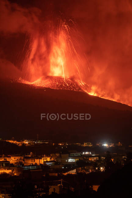 Lava calda e magma fuoriescono dal cratere vicino alle case di città. Cumbre Vieja eruzione vulcanica a La Palma Isole Canarie, Spagna, 2021 — Foto stock