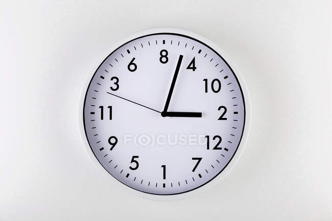Relógio minimalista em forma redonda com setas no fundo branco — Fotografia de Stock