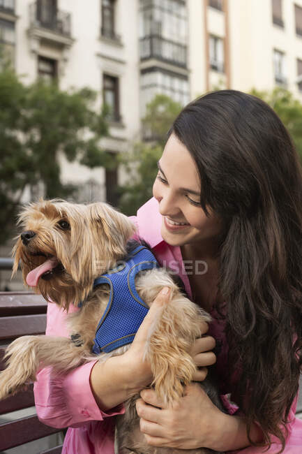 Allegro proprietario femminile sorridente ampiamente mentre si gode il tempo con divertente Yorkshire Terrier con la lingua fuori — Foto stock