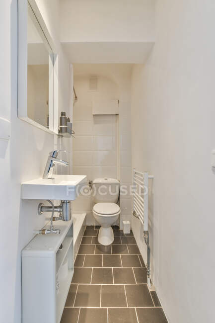 Intérieur de la petite salle de bain lumineuse vide avec lavabo propre et toilettes dans l'appartement — Photo de stock