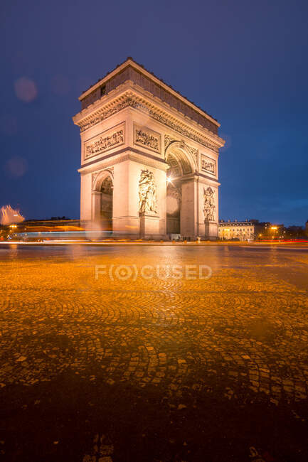 Alter Steinbogen mit Ornamenten und Statuen gegen Platz unter blauem Himmel in der Abenddämmerung im Winter Paris Frankreich — Stockfoto