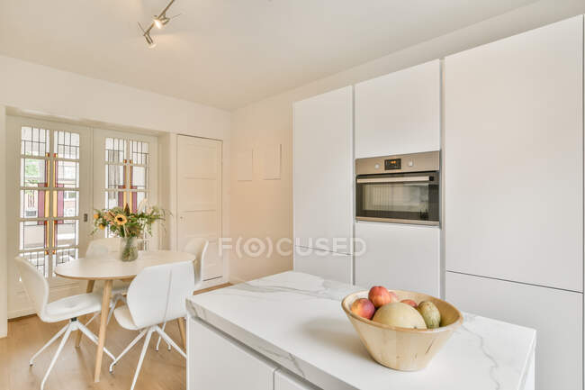 Interior of spacious kitchen with stylish light furniture in luxury modern apartments in daytime — Stock Photo