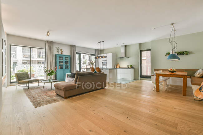 Sofas im geräumigen Zimmer mit moderner Küche mit Essecke und Gitarre — Stockfoto