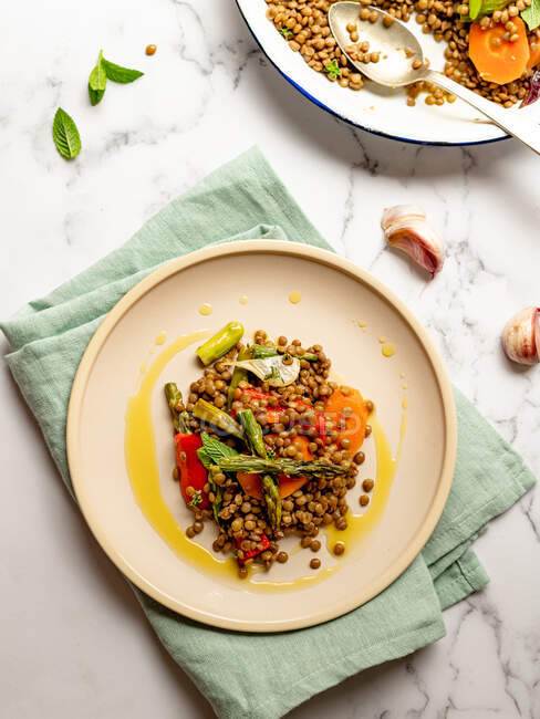Dall'alto di deliziosa insalata di lenticchie con verdure ed erbe servite in piatto sul tavolo di marmo — Foto stock