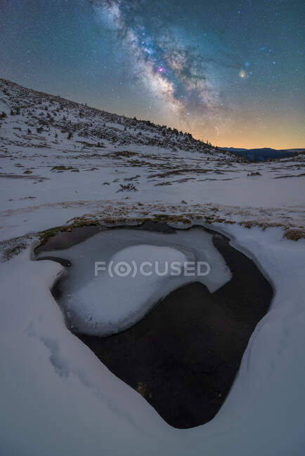 Ландшафт крижаної води біля гори під нічним зоряним небом з Чумацьким Шляхом. — стокове фото