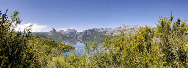 Picturesque panoramic landscape of Riano Reservoir surrounded by rocky mountains and green trees in sunny summer day with blue sky in Leon in Spain — Stock Photo