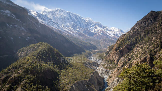 Picturesque landscape of curvy river flowing between high steep mountains with snowy peaks in highlands of Nepal — Stock Photo