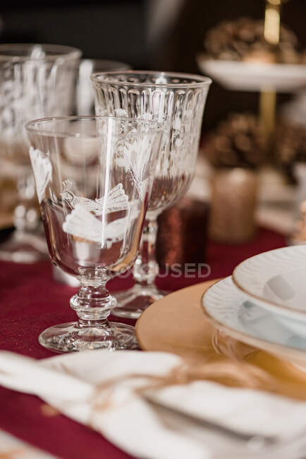 Crystal glasses with cutlery near plates on festive table served for Christmas dinner — Stock Photo