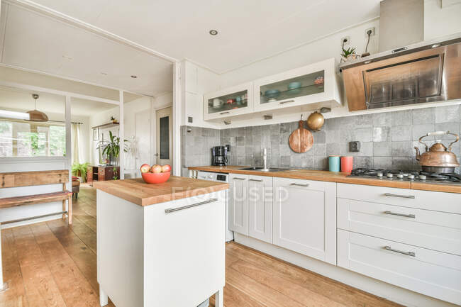 Intérieur d'une cuisine spacieuse avec des appareils modernes et des meubles blancs dans un appartement conçu dans un style minimal — Photo de stock