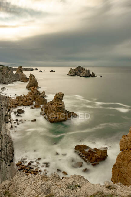 Cenário espetacular com ondas marinhas espumosas lavando formações rochosas ásperas de várias formas Costa Quebrada na Cantábria, Espanha — Fotografia de Stock