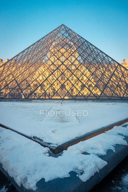 Пирамида Лувра из стекла и металла во внутреннем дворе Кур Наполеон старого дворца в Париже зимой — стоковое фото