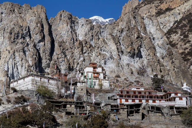 Shabby stone houses of Manang town located among high steep rocky Annapurna mountains in Nepal — Stock Photo