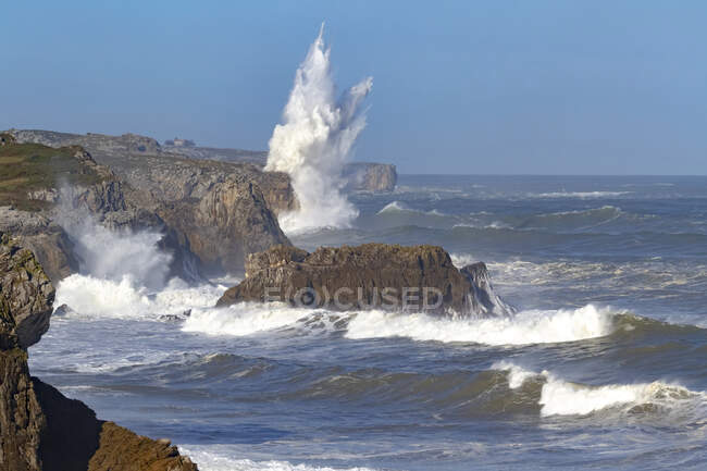 Вражаючі краєвиди з пінявими морськими хвилями промивають грубі кам 