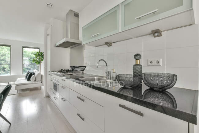 Stilvolles Glasgeschirr auf dunkler Küchentheke in geräumiger zeitgenössischer Wohnung tagsüber — Stockfoto
