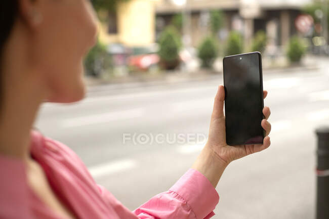 Ernte anonyme Frau steht auf dem Bürgersteig und fotografiert mit dem Handy in der Stadt — Stockfoto