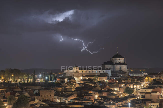 Paesaggio urbano di Toledo con torre ad alta età sotto cielo nuvoloso con fulmini durante il temporale durante la notte — Foto stock