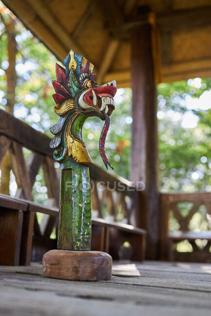 Escultura de dragón con adorno sobre pedestal en construcción envejecida de bambú en Bali Indonesia - foto de stock