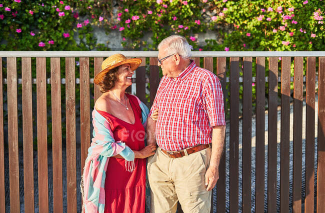 Feliz pareja de ancianos disfrutando caminar juntos de pie mirándose el uno al otro - foto de stock