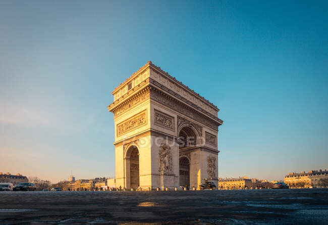 Arco de pedra velha com ornamento e estátuas contra quadrado sob céu azul ao amanhecer no inverno Paris França — Fotografia de Stock
