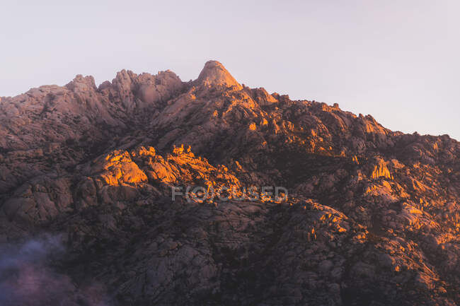 Vista panoramica di Pedriza con robusto monte e ombra sotto il cielo chiaro all'alba soleggiata in Spagna — Foto stock