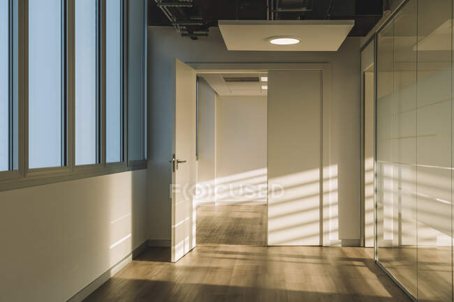 Innenraum eines leeren geräumigen Dachgeschosses mit geometrischen Schatten und Sonnenlicht an weißen Wänden — Stockfoto