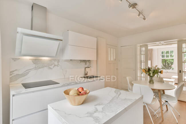 Innenraum der geräumigen Küche mit stilvollen, hellen Möbeln in luxuriösen, modernen Wohnungen tagsüber — Stockfoto