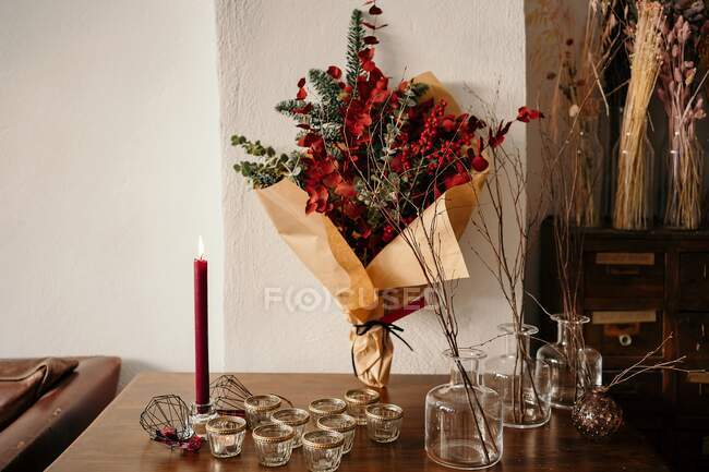 Stylish Christmas bouquet placed on festive table against light wall in room in daylight — Stock Photo
