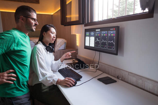 Optimistic diverse cryptocurrency traders analyzing graphs of cryptocurrency market and looking at screen — Stock Photo