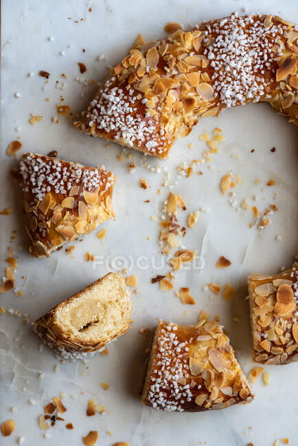 Delicious three kings cake pieces with coconut flakes and almond petals during Epiphany holiday — Stock Photo