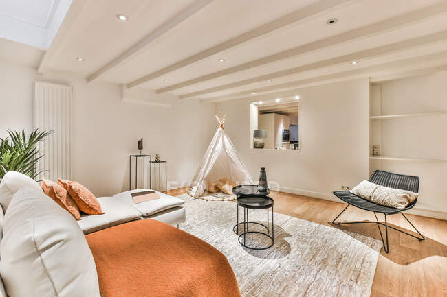 Interior contemporáneo de acogedora sala de estar con tienda de tipi y sofás en casa de campo residencial - foto de stock