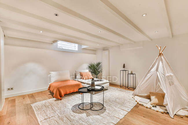Interno contemporaneo di accogliente salotto con tenda teepee e divani in cottage residenziale — Foto stock