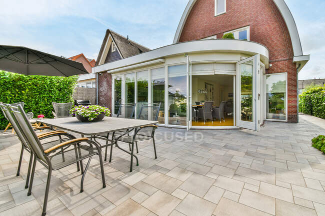 Conception créative de bâtiment résidentiel contre table et fauteuils sur la véranda sous un ciel nuageux à Utrecht Pays-Bas — Photo de stock