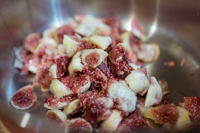 Figues mûres avec pulpe juteuse dans une casserole avec ornement à la maison sur fond flou — Photo de stock