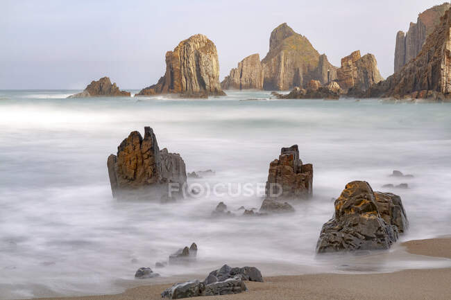 Spectacular scenery with foamy sea waves washing rough rocky formations of various shapes on wild beach of Geirua in Asturias Spain — Stock Photo