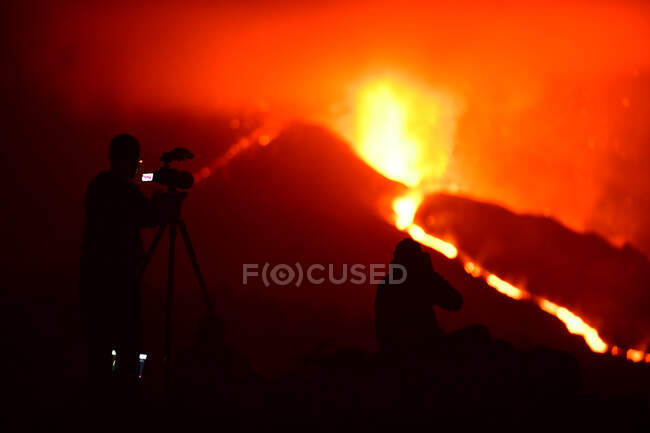 Silhuetas humanas da mídia gravando e fotografando com tripés a lava explosiva nas Ilhas Canárias de La Palma 2021 — Fotografia de Stock