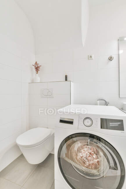 Інтер'єр світлої ванної кімнати з сучасною пральною машиною розміщений біля раковини і дзеркала в квартирі ванна кімната з душовою кабіною — стокове фото