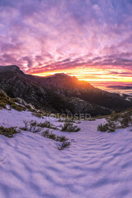 Paisagem cênica de montanhas rochosas no Parque Nacional da Serra de Guadarrama coberta de neve sob sol brilhante ao pôr do sol — Fotografia de Stock