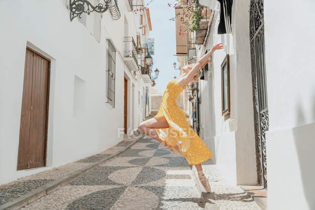 Graziosa ballerina in piedi in punta di piedi e alzando la gamba — Foto stock