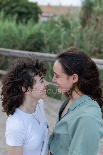 Vista lateral da jovem na moda com homossexual amado olhando uns para os outros na ponte — Fotografia de Stock
