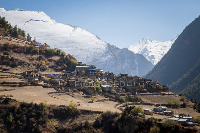 Case residenziali in pietra in villaggio su colline rocciose circondate da alta catena montuosa del circuito di Annapurna in Nepal — Foto stock